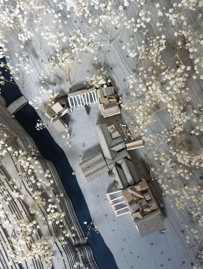 Top-down photograph of a grey-board architectural site model surrounded by dried flowers - Craft Cabin, Jesmond Dene.